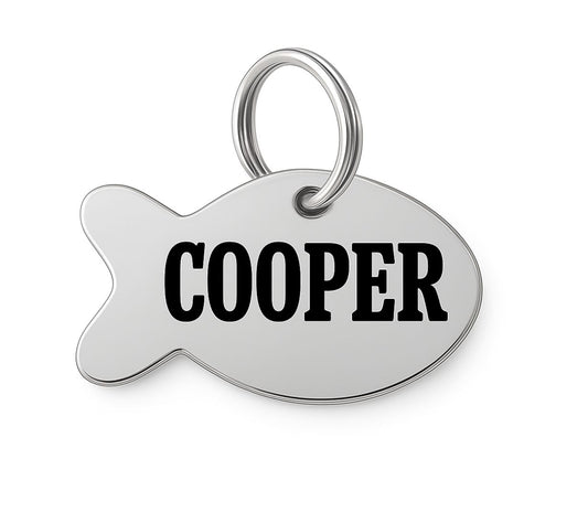 Silver fish-shaped stainless steel pet tag with 'COOPER' engraved on a white background